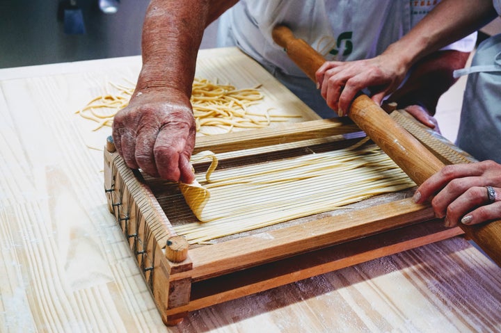 <p>Making pasta alla chitarra at a cooking class in Sulmona</p>