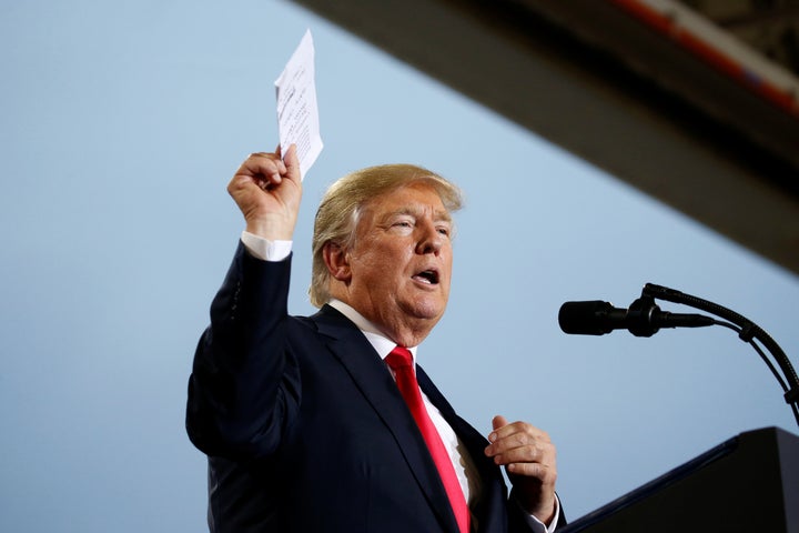 President Donald Trump holds up a list of politicians as he speaks about tax reform in Harrisburg, Pennsylvania, U.S., Octobe