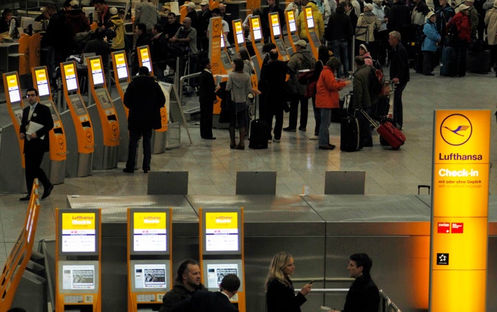 Passengers line up at a Lufthansa check-in counter at Frankfurt Airport