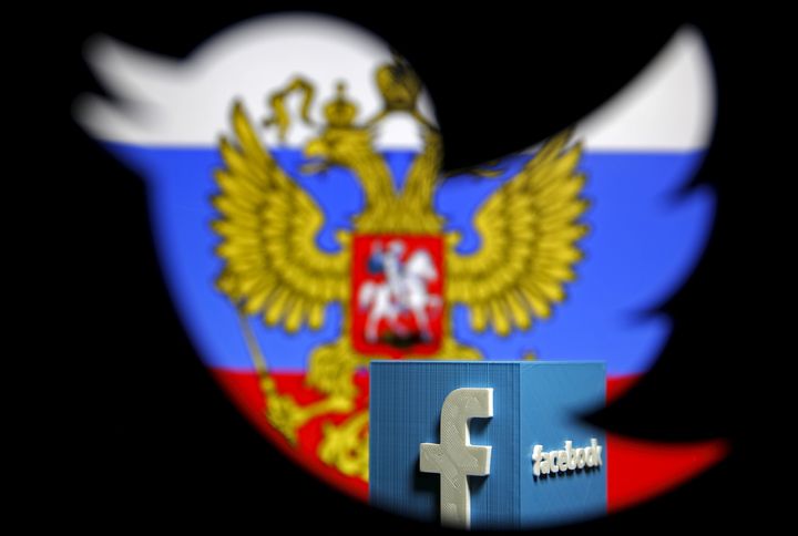 A Russian flag and a model of the Facebook logo are seen through a cutout of the Twitter logo in this photo illustration. 