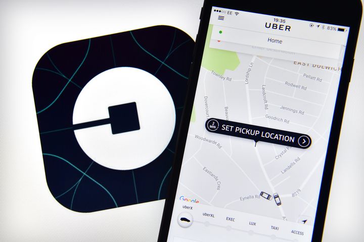 The Uber home page is displayed on an iPhone next to the company logo on a computer screen on August 3, 2016 in London, England. (Photo by Carl Court/Getty Images)