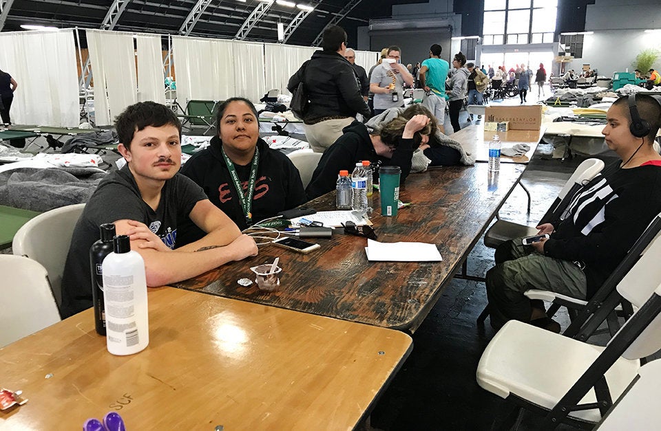 Bronson Katsanes (left), 19, a resident of SAY's long-term transitional housing program for homeless youth, sits with staff member Karina Calderon (center) at a Red Cross evacuation center in Santa Rosa after the wildfires -- Oct. 11, 2017