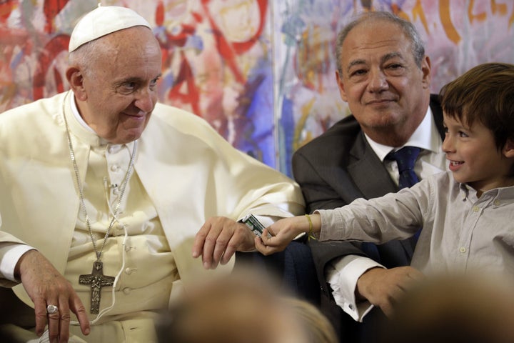 Pope Francis (L) looks at a child as he attends a meeting with members of the Scholas Occurrentes initiative, in Palazzo San Calisto in Rome on October 26, 2017.