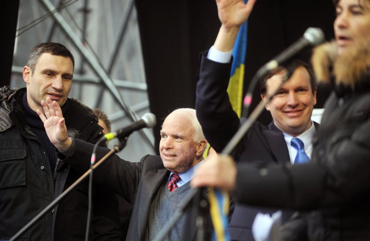 Senators John McCain and Chris Murphy wave to protestors as Ukrainian UDAR party leader Vitali Klitschko looks on during a mass rally in Kiev's Independence Square, December 15, 2013.