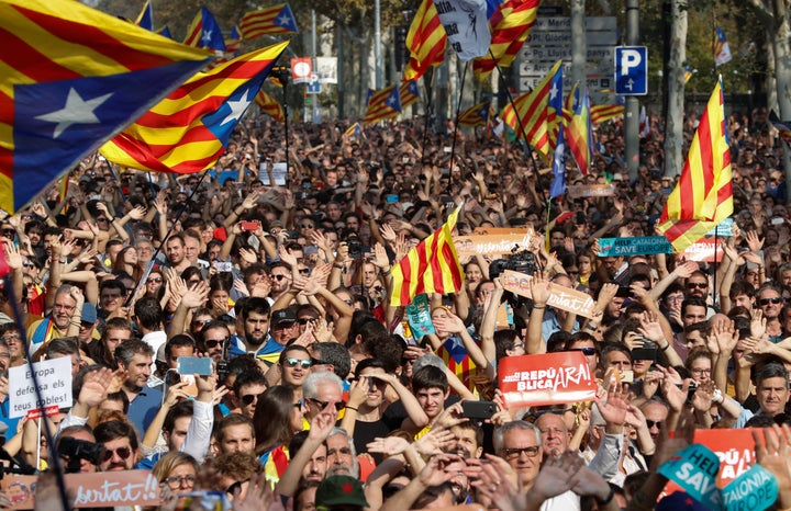 People react as they watch on giant screens a plenary session outside the Catalan regional parliament in Barcelona, Spain, October 27, 2017.