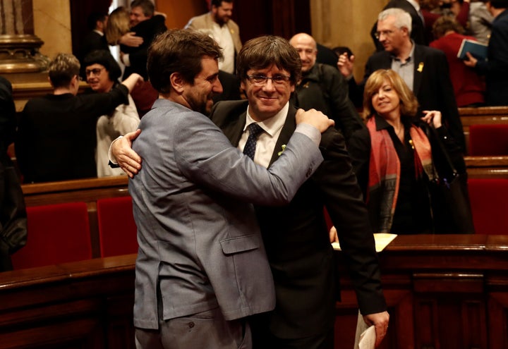 Catalan regional President Carles Puigdemont (R) celebrates after Catalonian Parliament declared independence following the s
