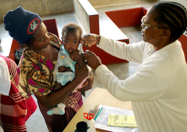 Health workers vaccinates child against measles at provincial hospital in Xai Xai, north of Mozambique's capital Maputo, August 11, 2005.