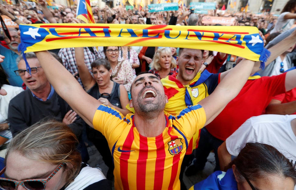 People react at Sant Jaume Square in Barcelona after the Catalan regional parliament declares independence from Spain.