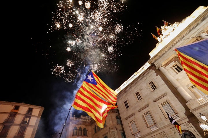 <strong>Catalan separatist flags are held up as fireworks go off in Sant Jaume Square in front of the Catalan regional government headquarters.</strong>