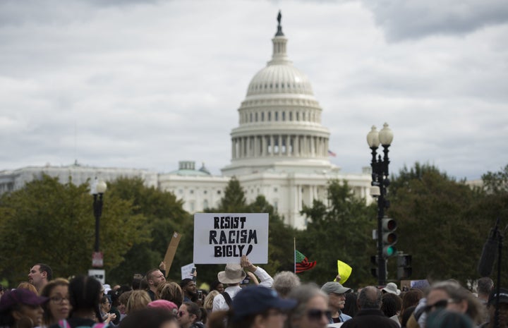 Protesters hold up banners as they march past the Capitol during the march for Racial Justice in Washington, DC, on Sept. 30,