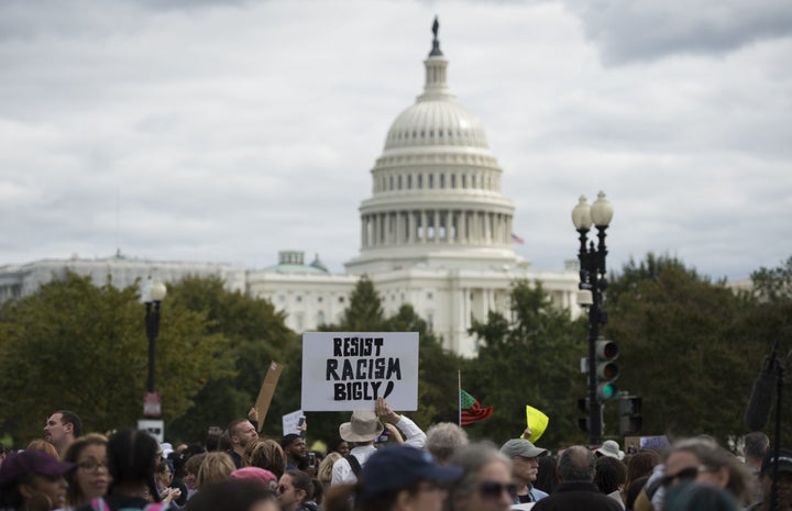 Protesters hold up banners as they march past the Capitol during the march for Racial Justice in Washington, DC, on Sept. 30, 2017.