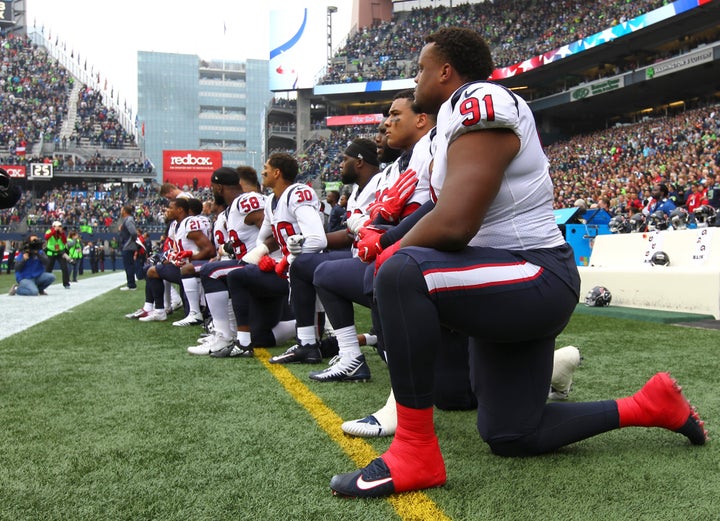 Texans player Carlos Watkins is pictured kneeling with his teammates on Sunday. 