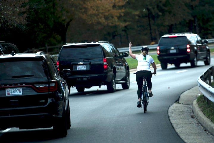 A female cyclist lets the White House know how she feels about the Trump administration as the president's motorcade passes by.