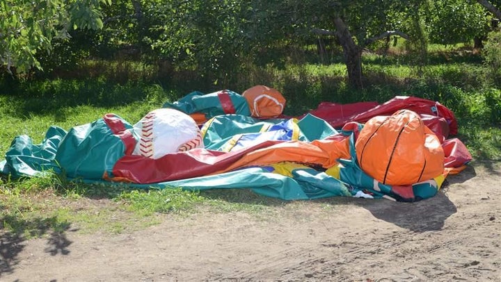 A deflated bounce house sits where it fell after soaring into the sky with two children inside at a Halloween festival in Nashua, New Hampshire, in 2014. Across the country, state regulations on inflatables are lacking, while injuries on the attractions are increasing.