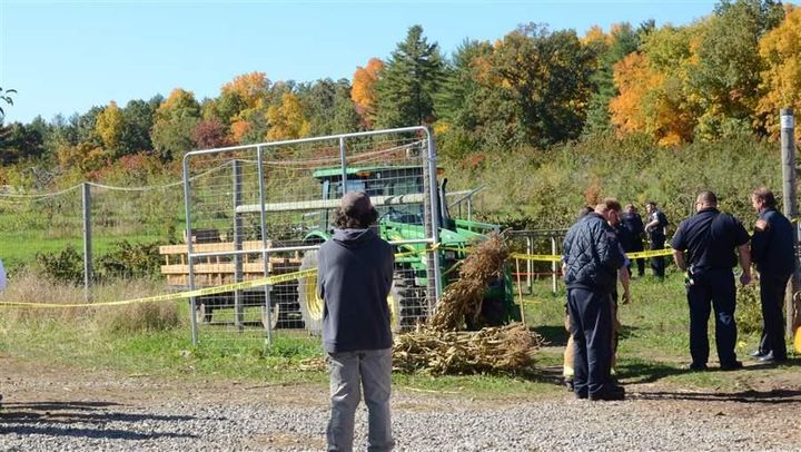 <p>Police and onlookers observe the scene at Sullivan Farm after two boys were injured when a bounce house they were playing in lifted off the ground.</p>