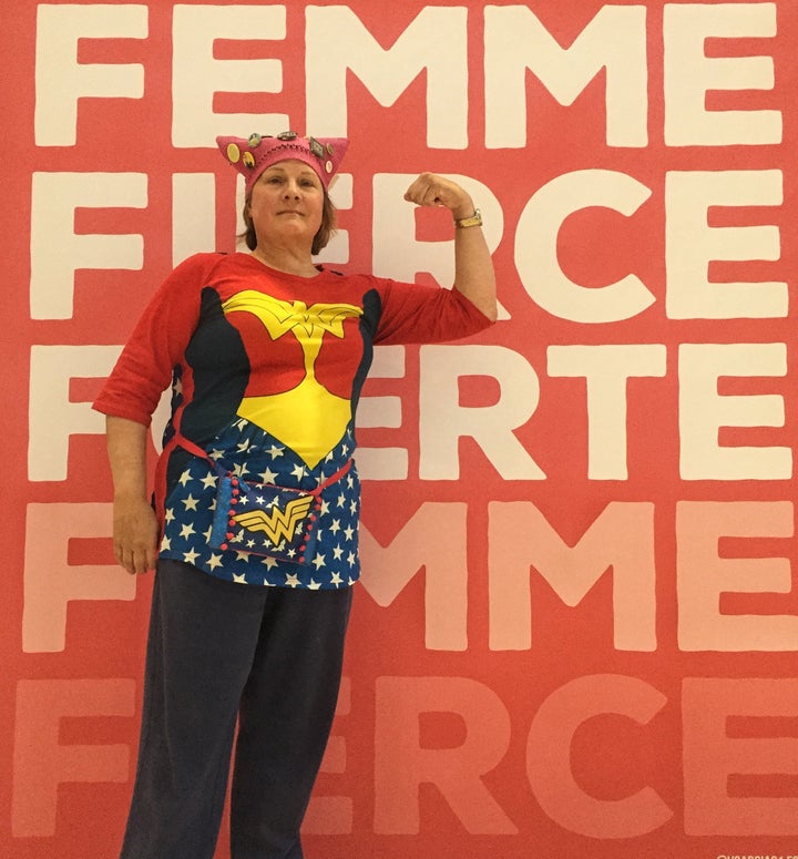 Karen Dunnam, 60, posed in front of a poster at the Women's Convention wearing her fall "pussy hat."