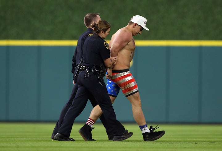 Security workers escort Vitaly Zdorovetskiy off the field.