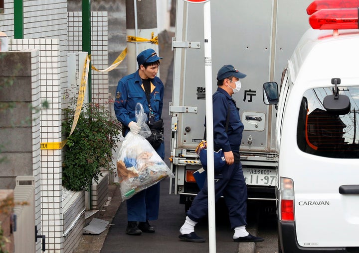 A police officer carries a plastic bag from the apartment building where up to nine dismembered bodies were reportedly found 