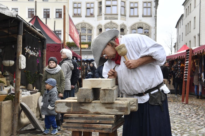 A traditional wood cutter engraves wood in the main square in Wittenberg, eastern Germany, where celebrations take place on the occasion of the 500th anniversary of the Reformation on October 31, 2017.