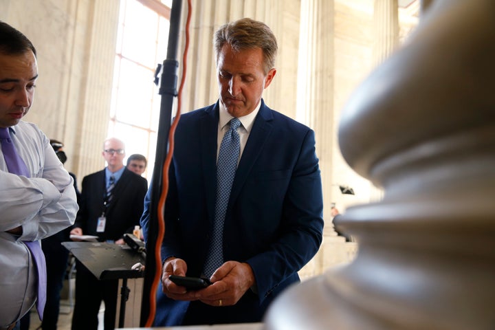 Sen. Jeff Flake (R-Ariz.) pauses to check his phone after announcing he will not run for re-election on Oct. 24, 2017.