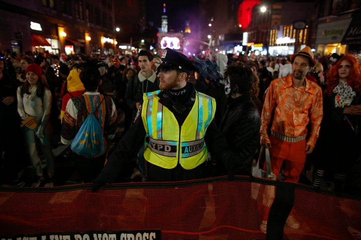 NYPD officers stand guard during the Halloween parade hours after a man driving a rental truck struck and killed eight people in lower Manhattan.