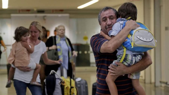 Cori Rojas, left, carries her daughter through JFK Airport after a flight from San Juan, Puerto Rico. Rojas, a school teacher, left the island after Hurricane Maria and is staying with her father-in-law, Juan Rojas, right. New York is offering one-year certificates to teachers from Puerto Rico.