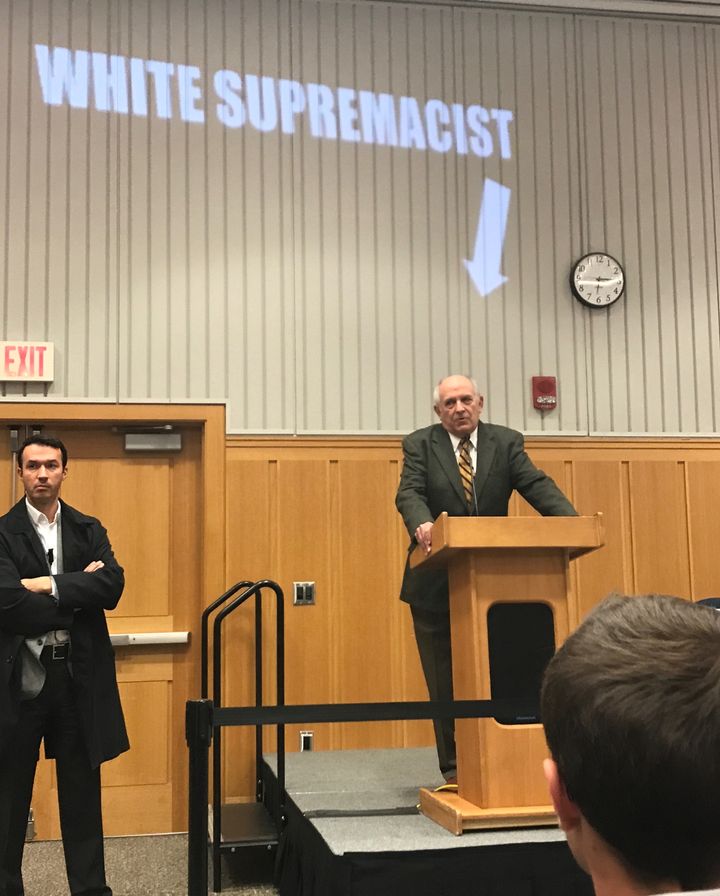 Protestors project "White Supremacist" above Charles Murray during his speech at the University of Michigan.