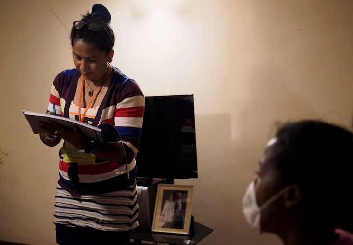 Volatiana Raharimananjarahoby, a community health agent in Antananarivo, with the mother of a girl who caught the plague. She runs through her checklist to make sure no one else in the family has symptoms.