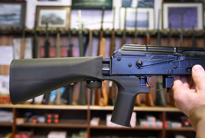 A bump stock device, which fits on a semi-automatic rifle to increase the firing speed, is installed on an AK-47 at a gun store.