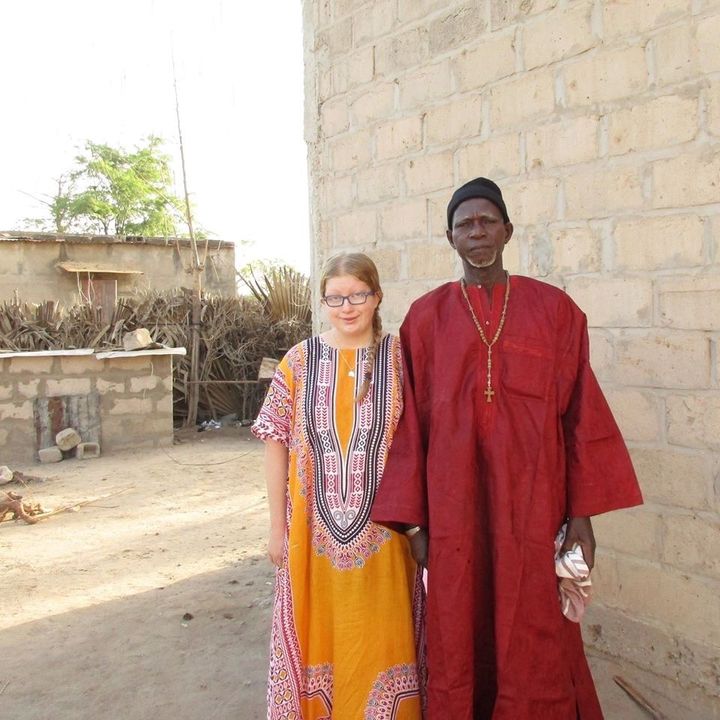 Thea and her host father Bú outside their house in Senegal.