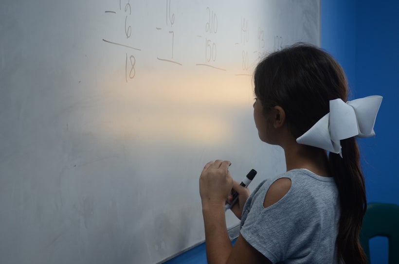 A young girl ponders her answer while studying math problems at Educare in Dearborn, Mich.