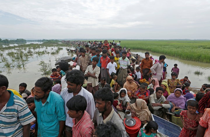 <i></i>Rohingya refugees wait to be taken to a refugee camp after crossing the Naf river at the Bangladesh-Myanmar border on