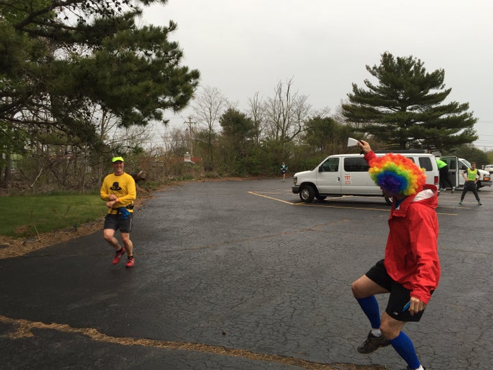 Clown wig. Cowbell. Smiling runner. This spectator is clearly a veteran. 