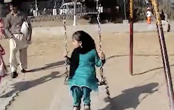 A young girl enjoys time on the swings 