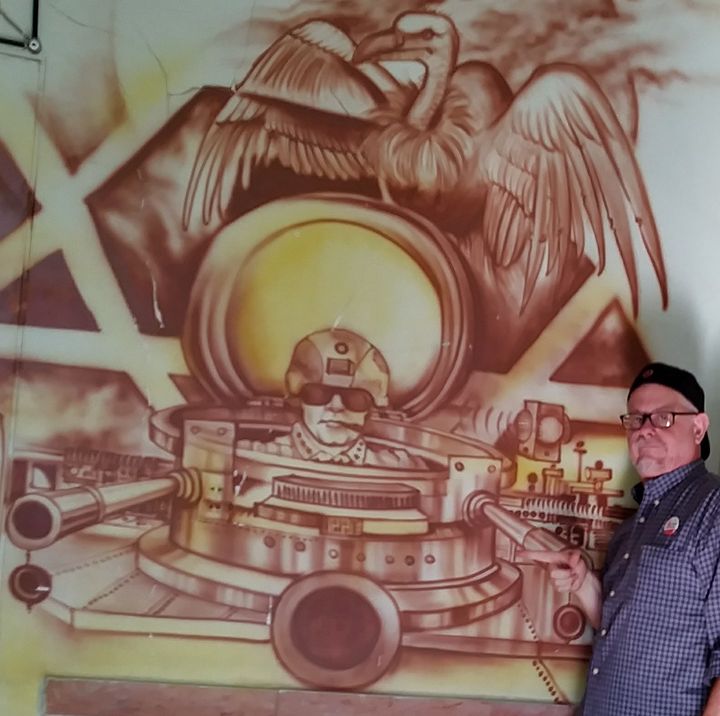 Author beside vivid anti-US artwork inside the “American Espionage Den,” the one-time besieged United States Embassy.