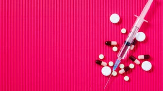 Pills and syringe. Pills and syringe on red background. Copy spaceMedical syringe. Syringe for insulin on a red backgroundMedical preparations, pills and capsules and syringe lie on blue background. Copy spaceMedical syringe. Syringe for insulin on a red background