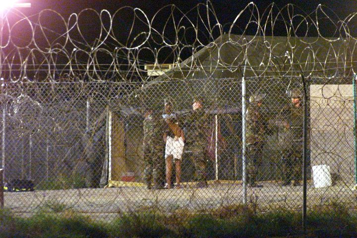 A newly arrived detainee is escorted into a processing tent in 2002.