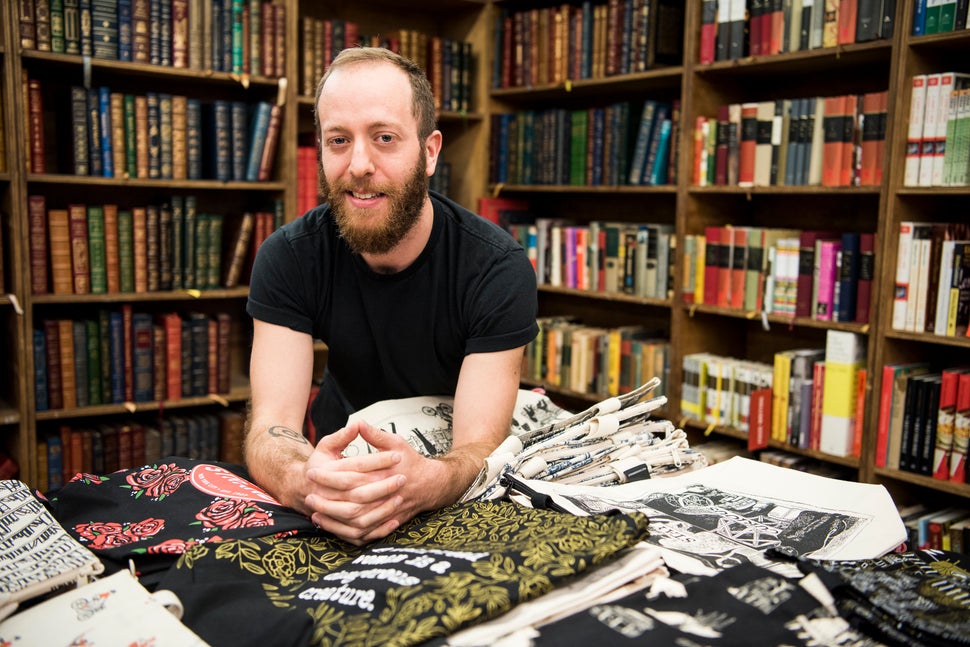 Strand designer Topher MacDonald with several of the tote bags he designed.
