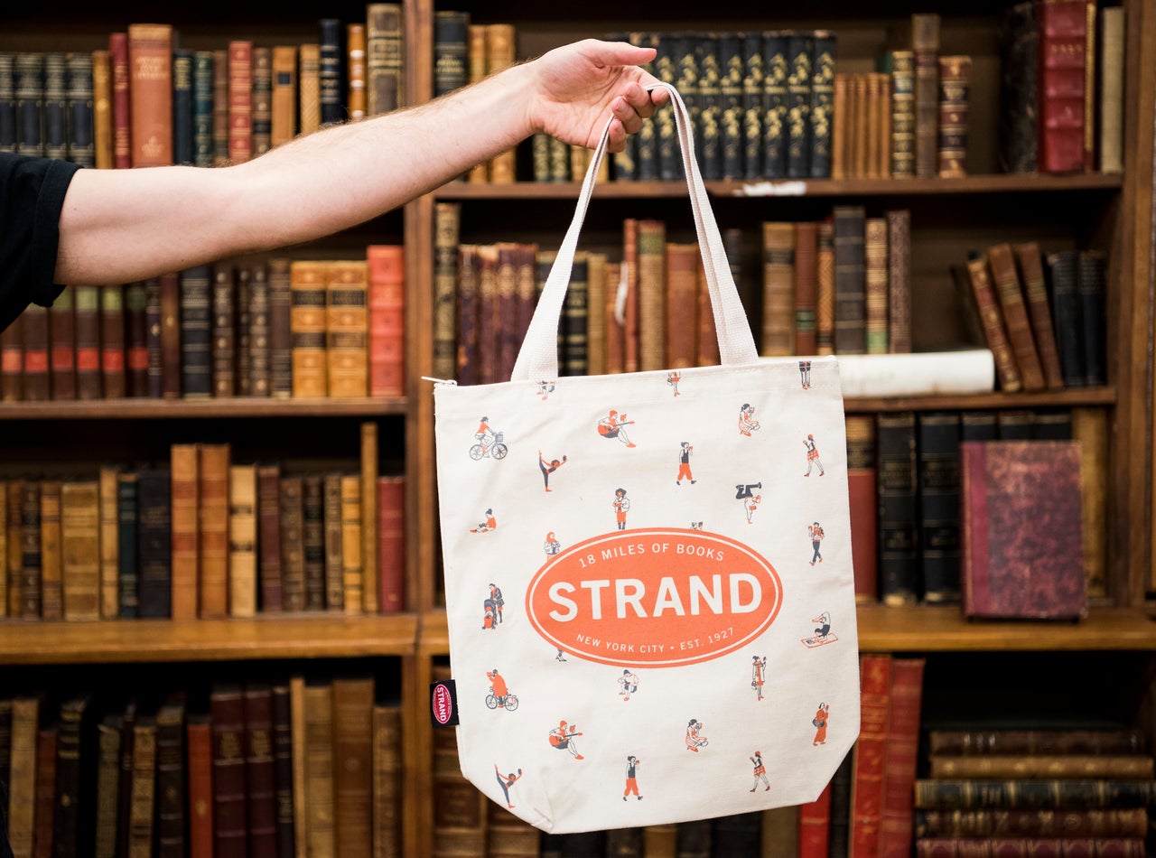 Topher MacDonald holds up one of his designs, titled "NYC Readers," at the Strand Book Store in New York City on Nov. 2, 2017.