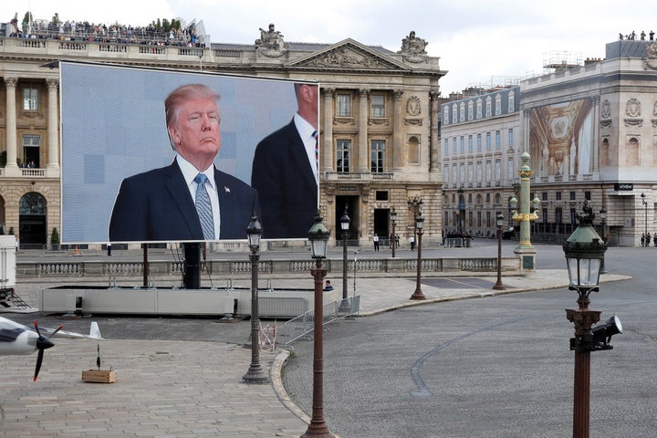 U.S. President Donald Trump appears on a giant screen on the Place de la Concorde during the traditional Bastille Day militar
