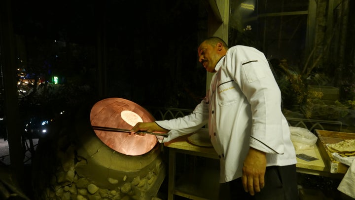 Daily bread—The disc inside the fiery clay drum is traditional tannor bread prepared at Sufra in Amman.