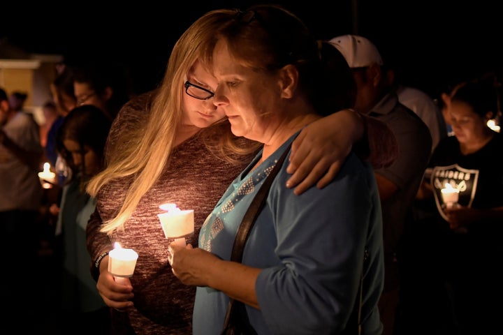 People embrace during a candlelight vigil for victims of a mass shooting at a church in Sutherland Springs, Texas.