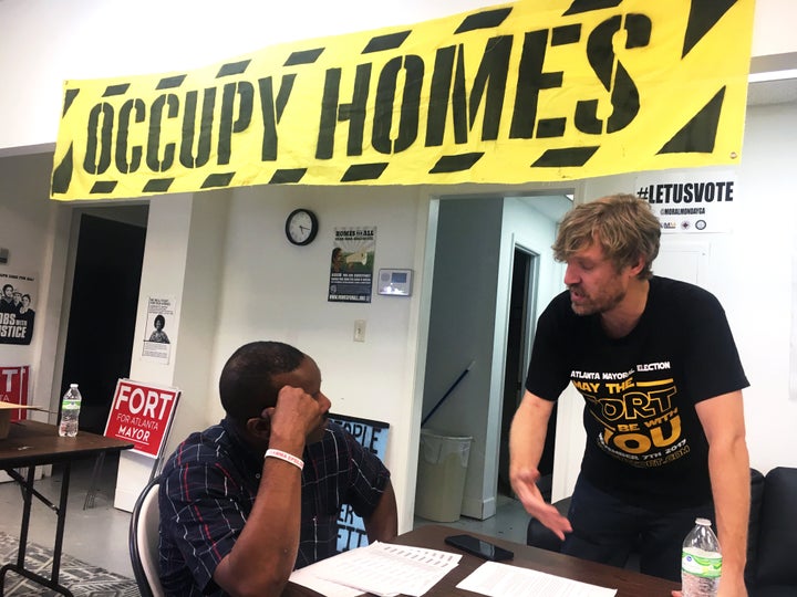 Tim Franzen (right), community outreach director for Fort's campaign, walks a volunteer through the phone-banking process.