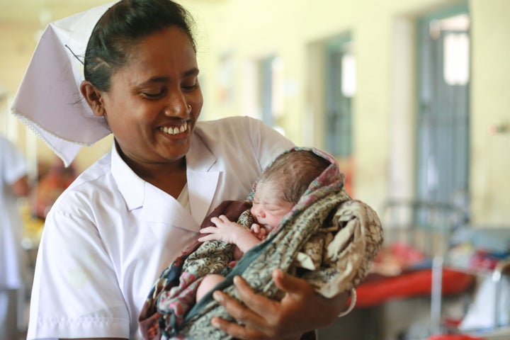 A midwife in Bangladesh holds a 1-day-old baby.