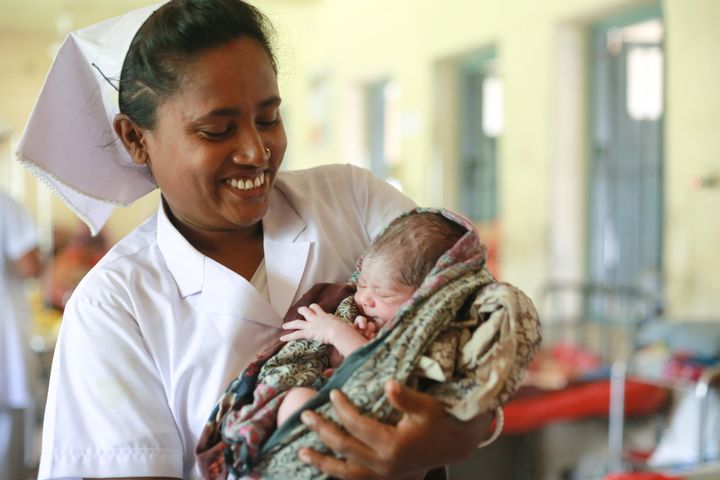 A midwife in Bangladesh holds a 1-day-old baby. 