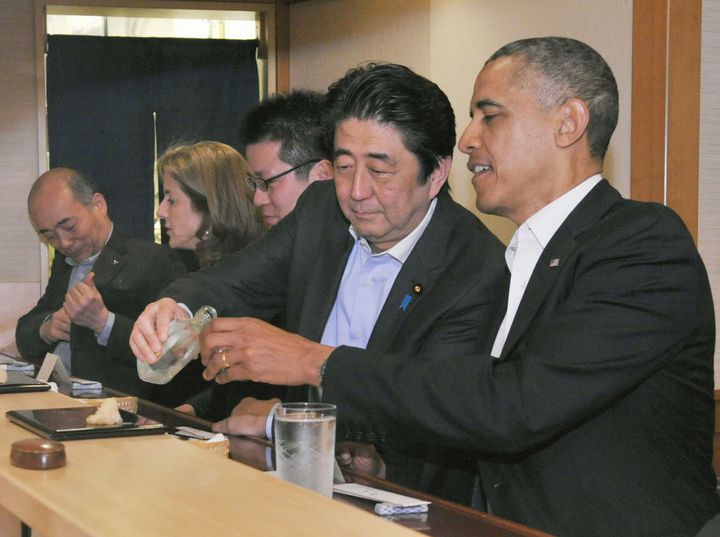 Japanese Prime Minister Shizo Abe fills U.S. President Barak Obama's glass during dinner at Sukiyabashi Jiro sushi restaurant in Tokyo on April 23, 2014.