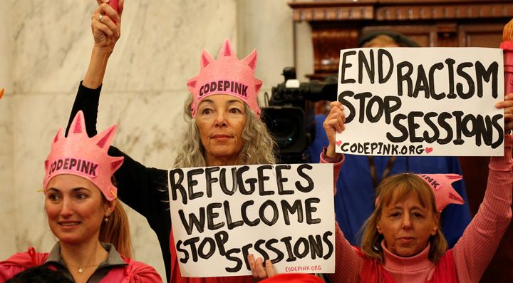 Protesters hold signs at the Senate Judiciary Committee confirmation hearing for Jeff Sessions to become U.S. attorney general on Jan. 10, 2017.