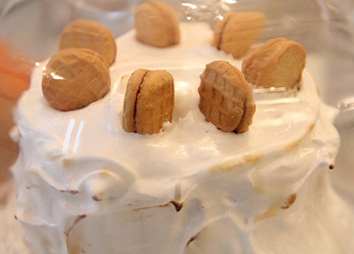 Nutter Butter cookies decorate a peanut butter and fluff cake that is frosted in meringue.