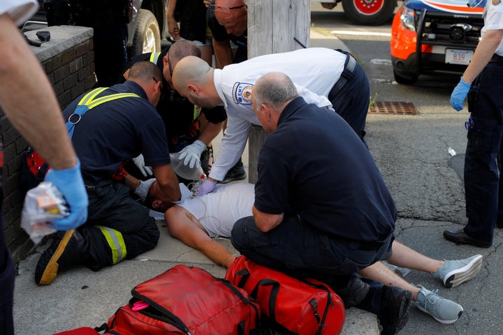 Paramedics and firefighters treat a 32-year-old man who was found unresponsive on a sidewalk after overdosing on opioids in Everett, Massachusetts, on Aug. 23, 2017.