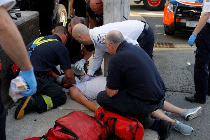 Paramedics and firefighters treat a 32-year-old man who was found unresponsive on a sidewalk after overdosing on opioids in Everett, Massachusetts, on Aug. 23, 2017.